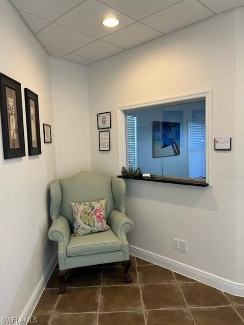 Sitting room with a drop ceiling and tile patterned flooring