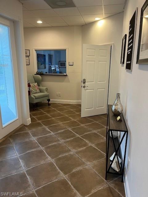 Entryway featuring a drop ceiling and baseboards