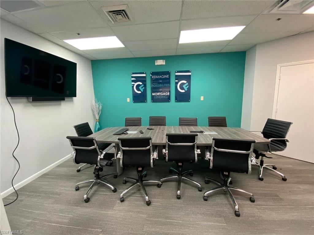 Office area with a drop ceiling, carpet flooring, and baseboards
