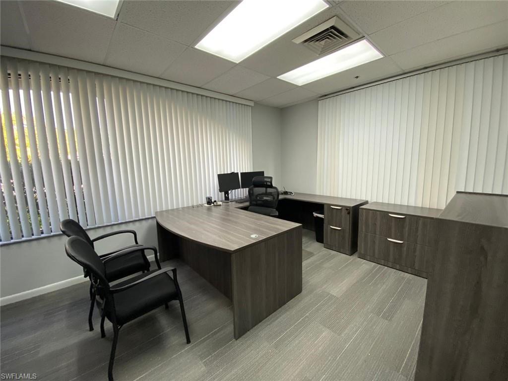 Office with a paneled ceiling and baseboards