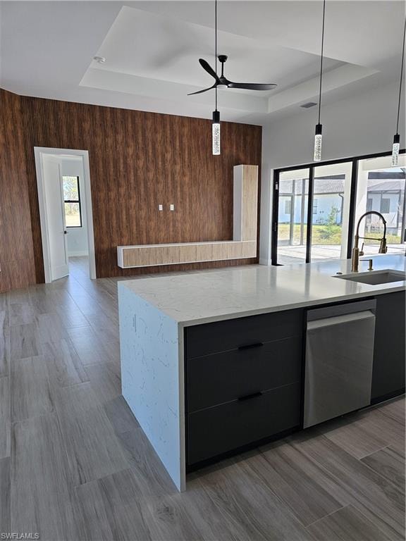 Kitchen with a sink, modern cabinets, a raised ceiling, and dishwasher
