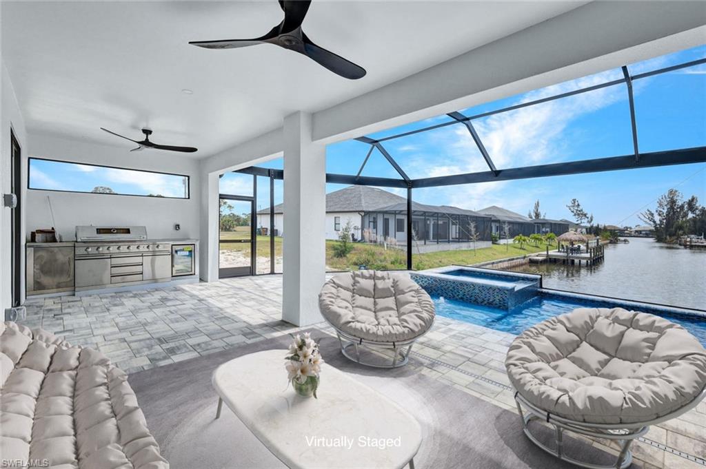 View of patio with an in ground hot tub, ceiling fan, an outdoor kitchen, and an outdoor pool