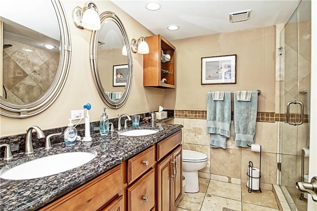 Kitchen featuring a raised ceiling, stainless steel appliances, light stone countertops, open floor plan, and backsplash
