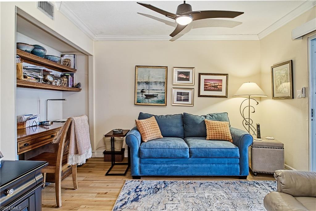 Bedroom with light carpet, ornamental molding, and a ceiling fan