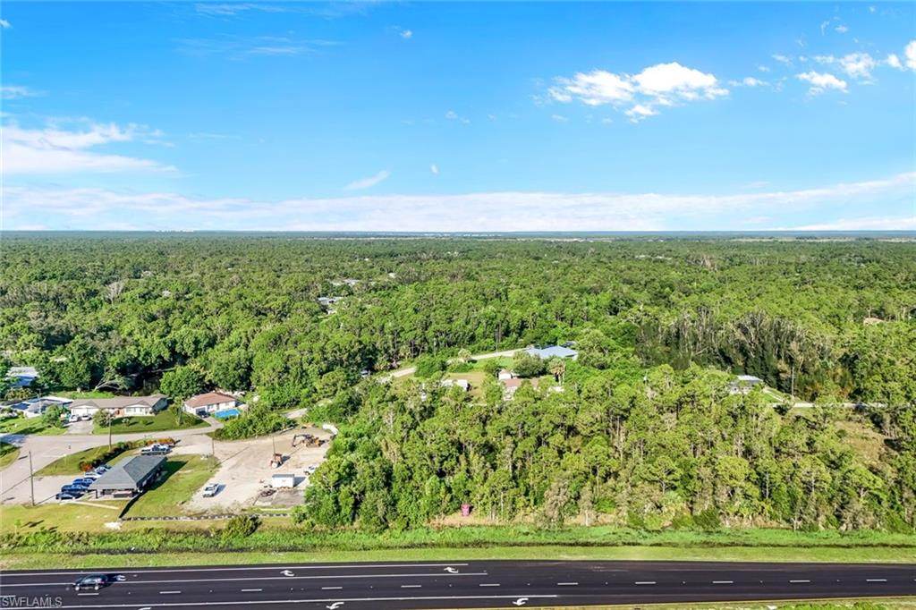 Aerial view of property and surrounding area with a forest