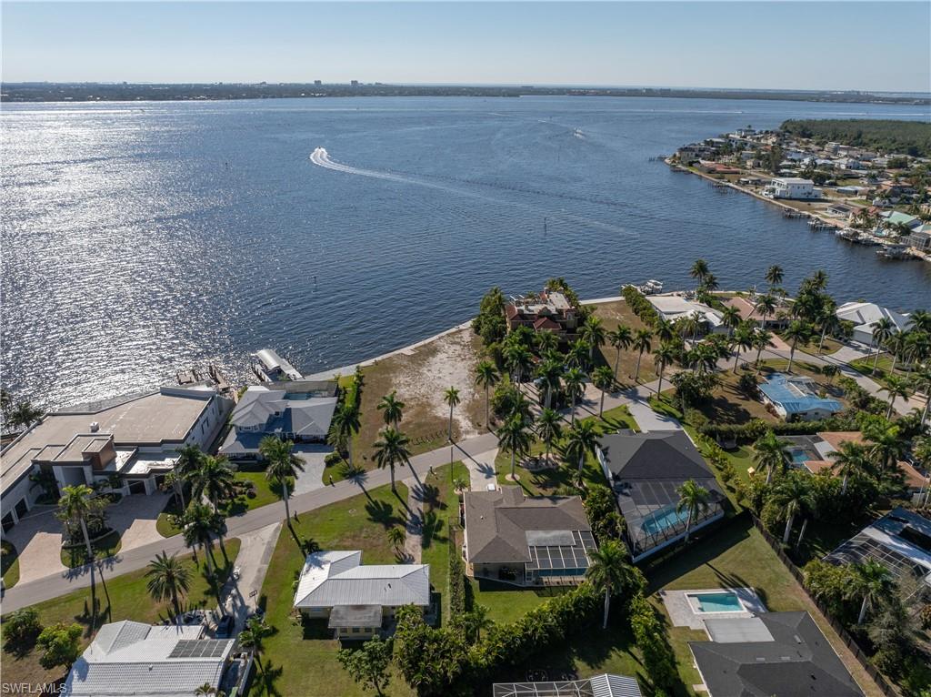 Aerial view of property and surrounding area featuring nearby suburban area and a large body of water