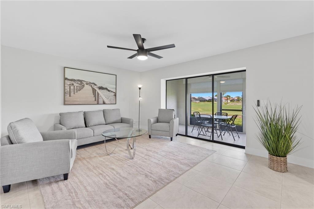 Living room featuring light tile patterned floors and ceiling fan