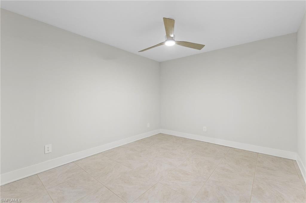 Unfurnished room featuring light tile patterned flooring and ceiling fan