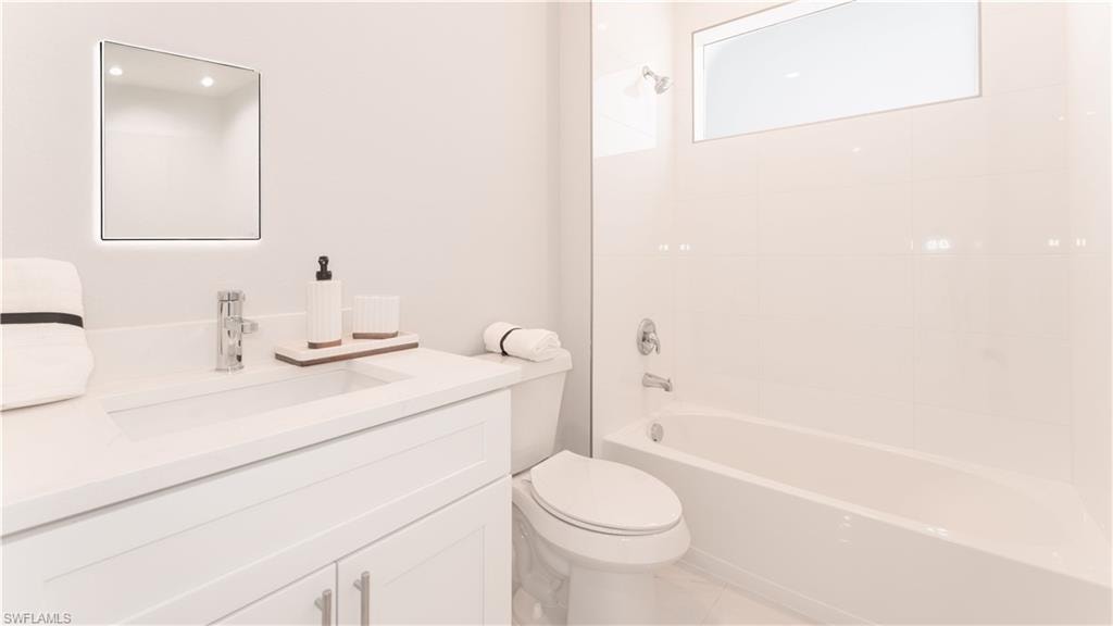 Guest Full bathroom featuring toilet, vanity, and tiled shower / bath combo