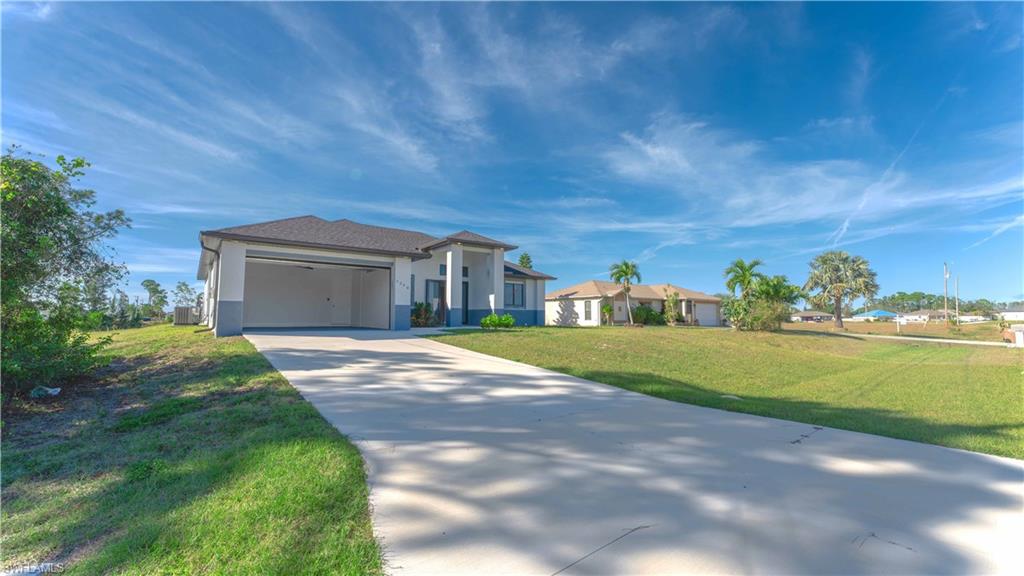 Single story home with a garage and a front yard