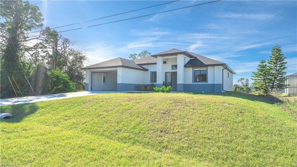 View of front of property featuring a front lawn and a garage
