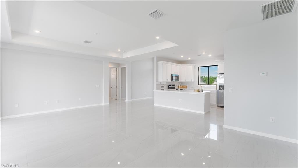 Unfurnished living room featuring a tray ceiling