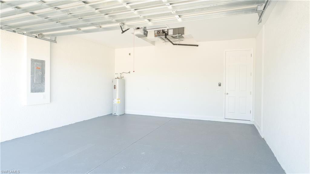 Garage featuring electric panel, a garage door opener, and electric water heater