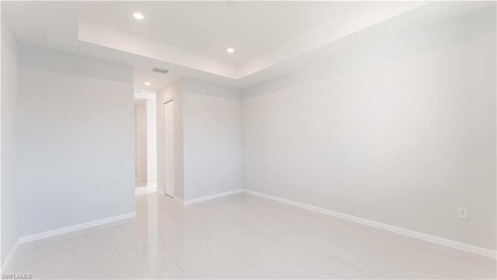 Primary Unfurnished room featuring a raised ceiling