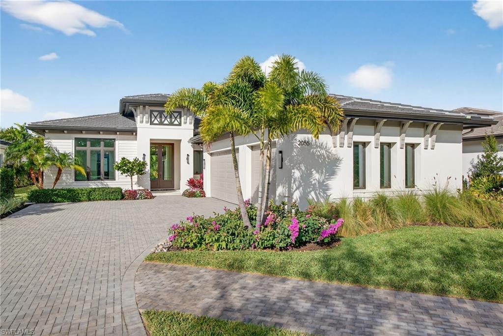 Coastal contemporary architecture house featuring decorative paver driveway, stucco siding, an attached 3 garage, and a tiled roof