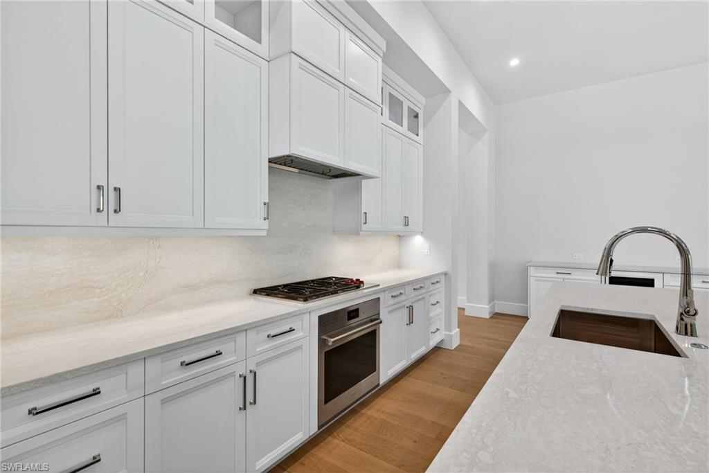 fabulous gourmet-inspired kitchen featuring Sub Zero and Wolf appliances, custom designer wood cabinetry as well as a large island breakfast bar