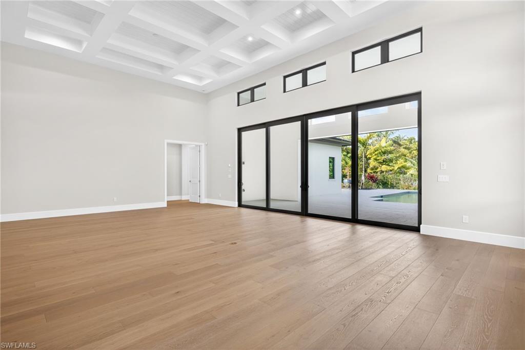 The large great room with open an concept family style design is bright and airy ,lovely wood floors, plenty of natural lighit flows through the sliding glass doors