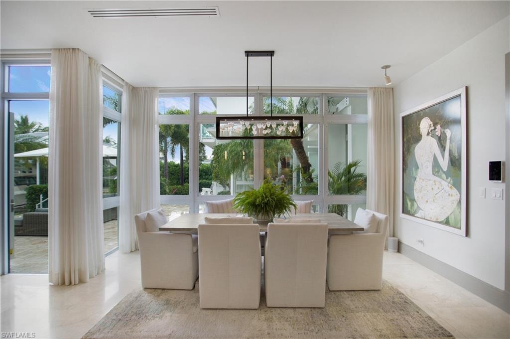 Expansive dining area featuring a linear chandelier over a rectangular table