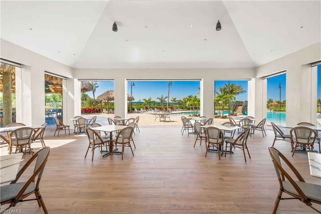 Dining space with light hardwood / wood-style flooring and lofted ceiling