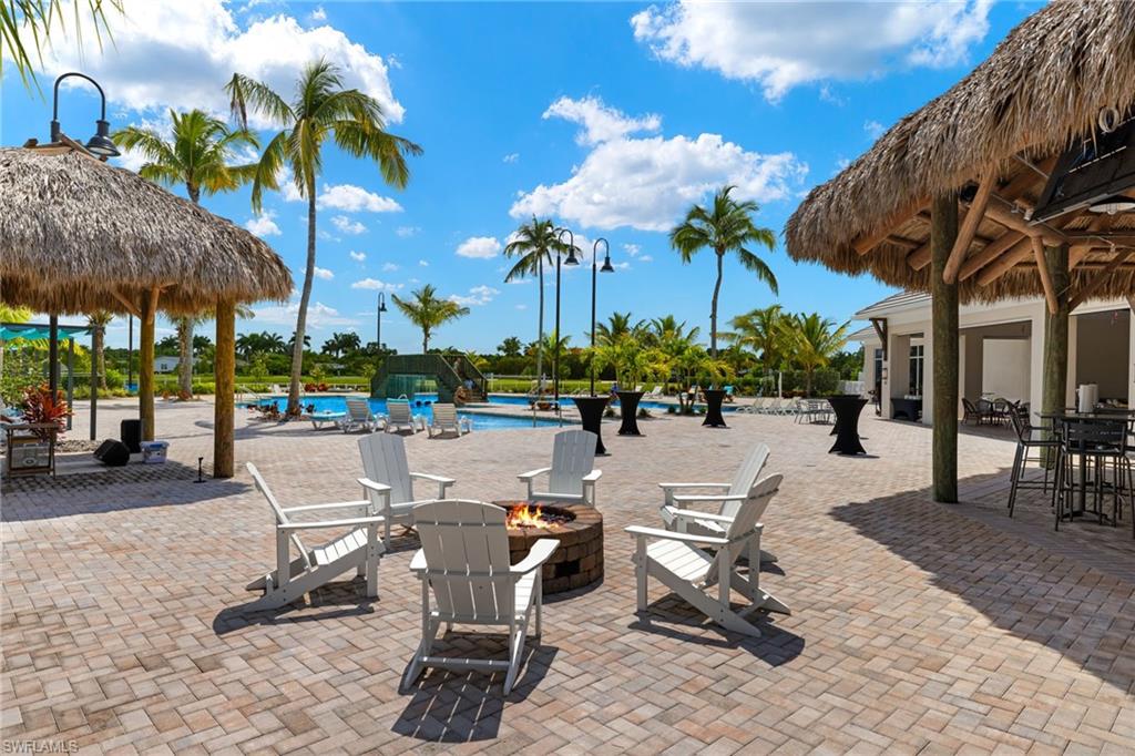 View of patio with a gazebo, an outdoor fire pit, and a community pool