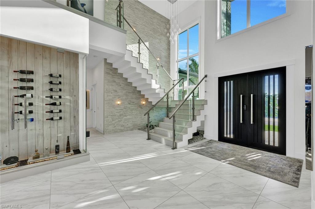 Floating staircase w/solid quartz treads & glass railings plus a custom front entry door