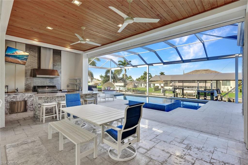 Outdoor Kitchen has a 36" grill, stainless steel cabinets, exotic level granite, ice maker/beverage cooler & tiled backsplash