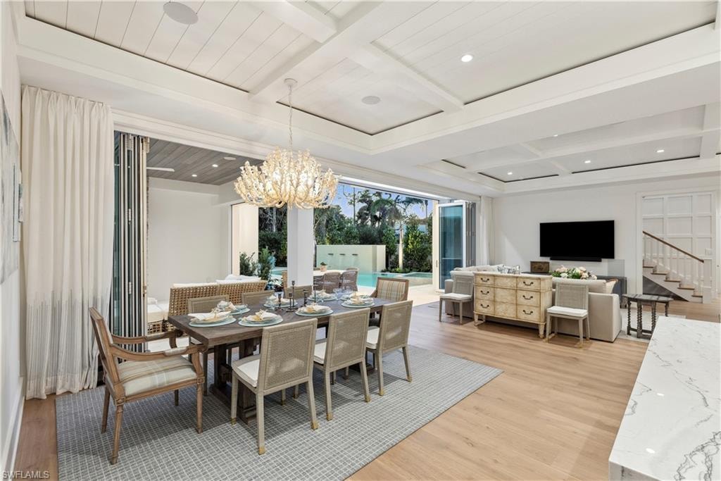 Dining area with coffered ceiling, wood ceiling, a chandelier, beamed ceiling, and light hardwood / wood-style floors