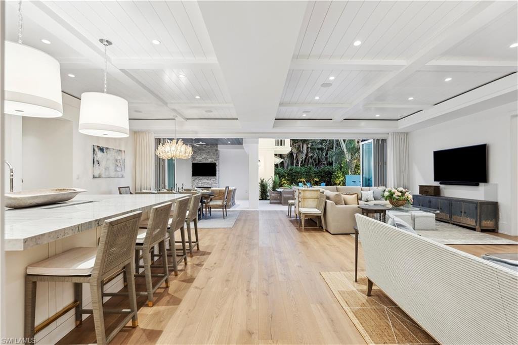 Living room with beam ceiling, coffered ceiling, and light hardwood / wood-style floors