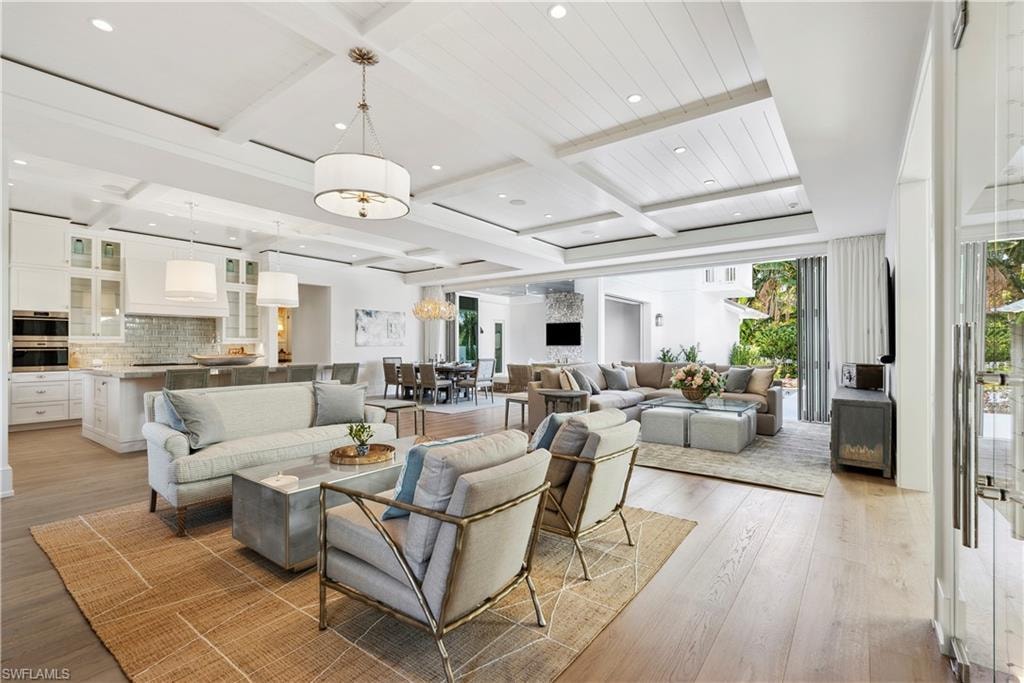 Living room featuring beam ceiling, coffered ceiling, and light hardwood / wood-style floors