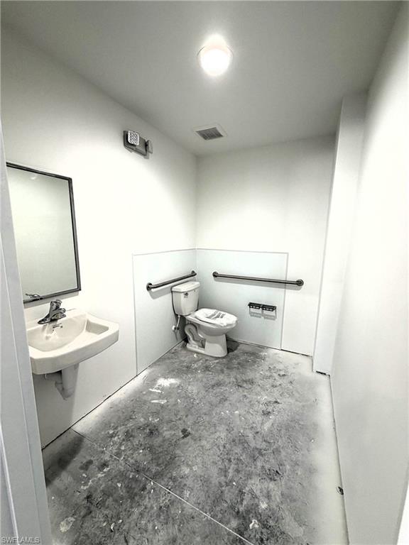 Half bath with toilet and concrete flooring
