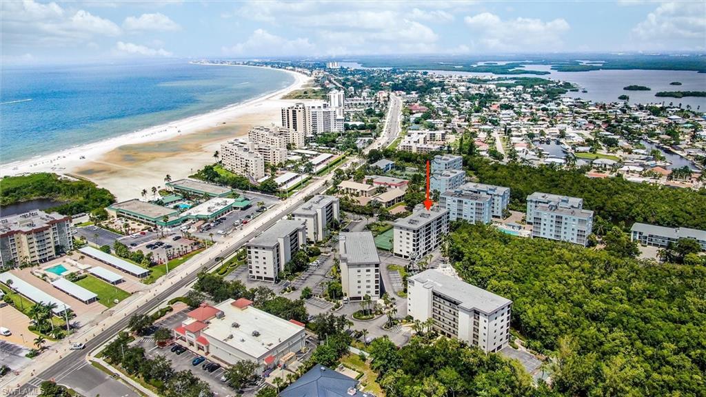 Birds eye view of property with a beach view and a water view