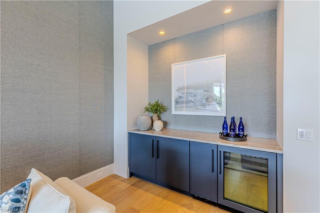 Dry bar equipped with wine fridge and ice maker.