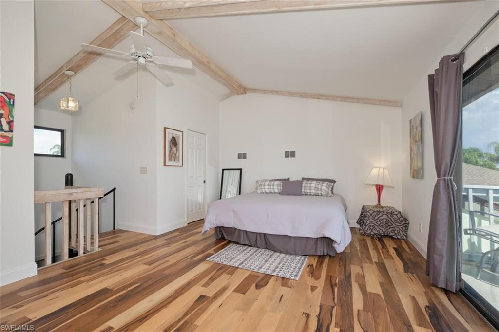 Bedroom featuring vaulted ceiling with beams, ceiling fan, hardwood / wood-style flooring, and access to exterior