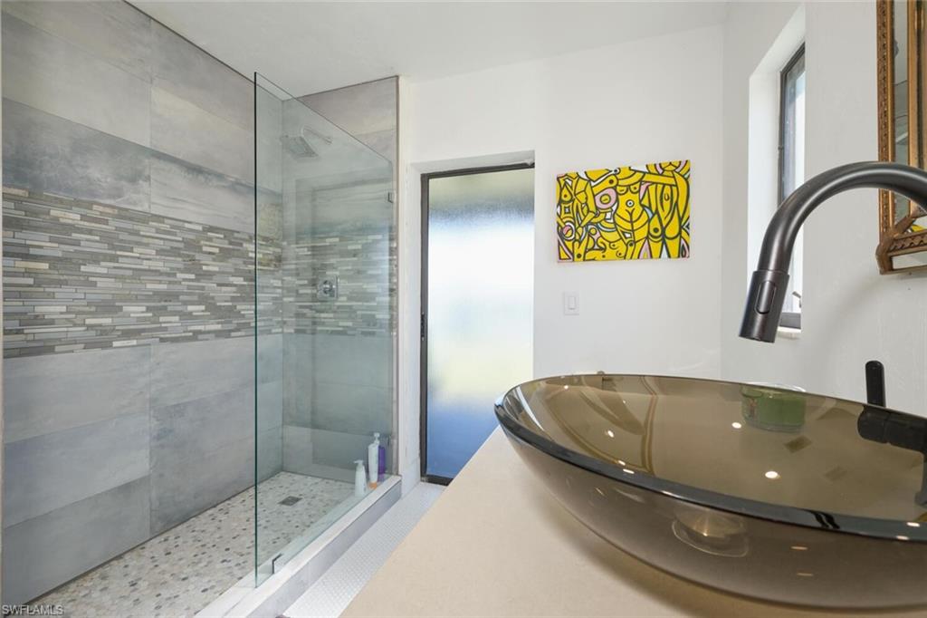 Bathroom with sink, walk in shower, and tile floors