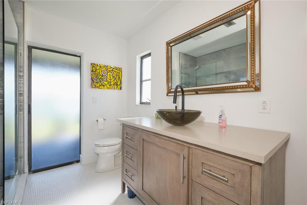 Bathroom with tile flooring, vanity, and toilet