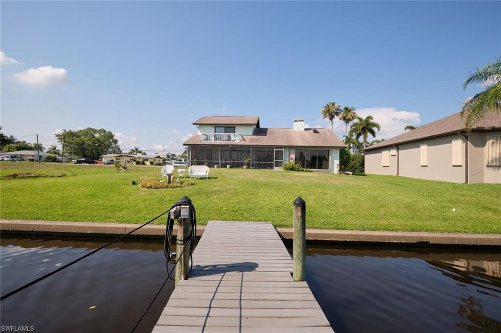 Dock area with a water view and a yard
