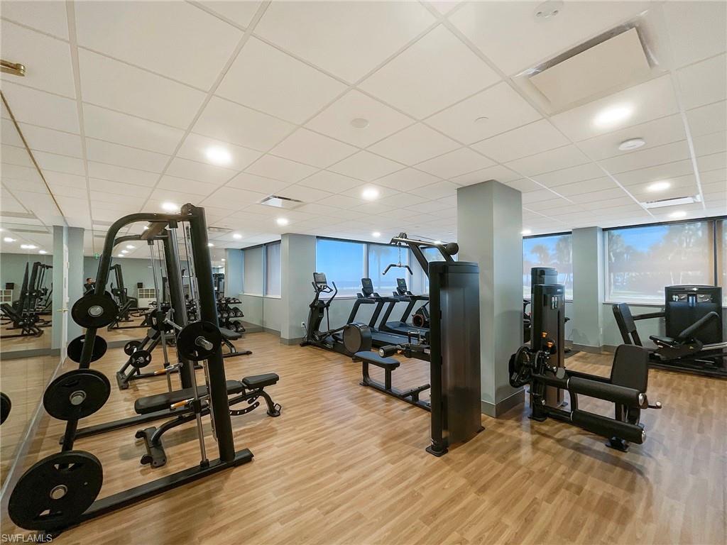 Workout area with a drop ceiling, light wood-style floors, and recessed lighting
