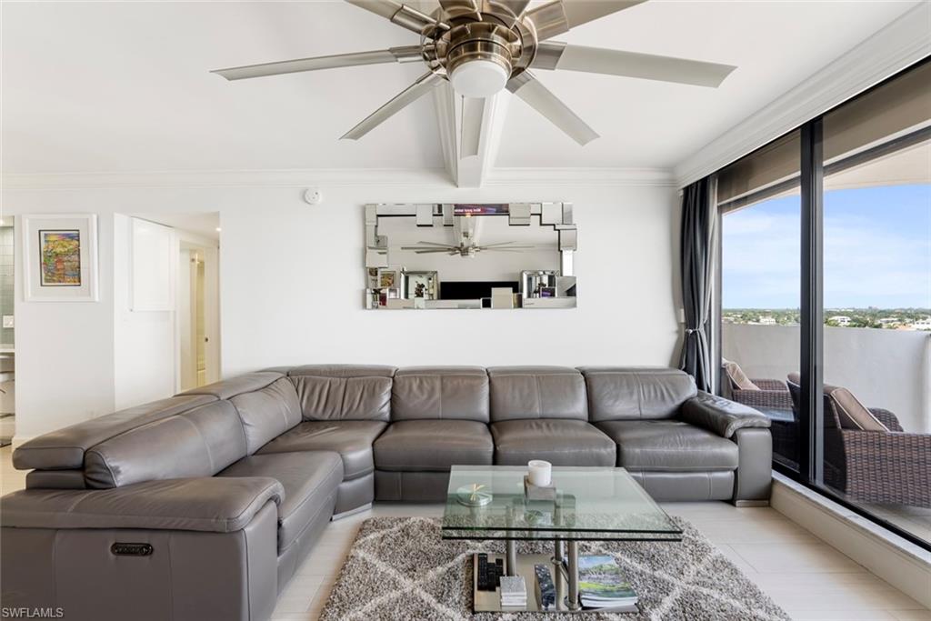 Living room featuring light hardwood tile style floors, ceiling fan, and crown molding