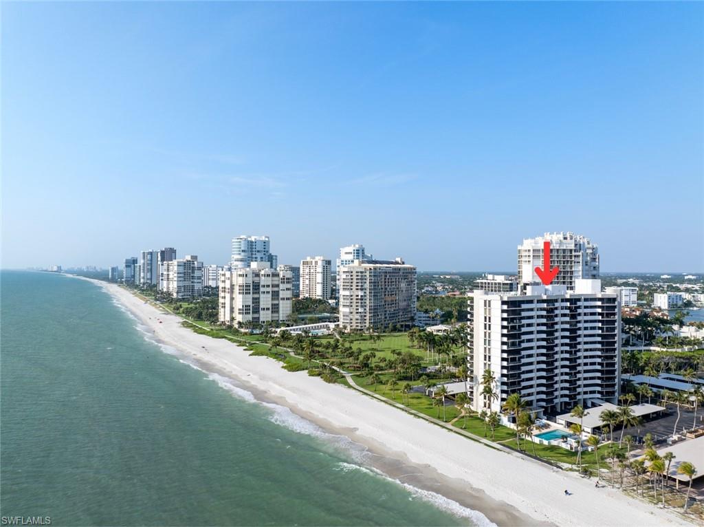 Birds eye view of property with a beach view and a water view
