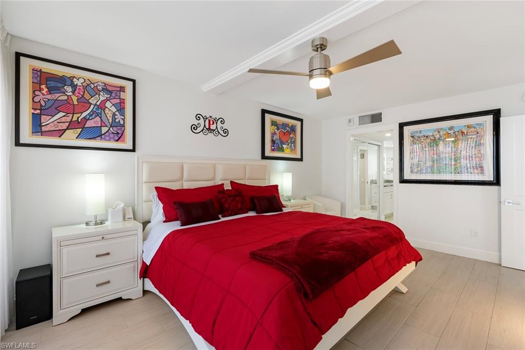 Bedroom featuring ensuite bath, ceiling fan, and light wood-type flooring