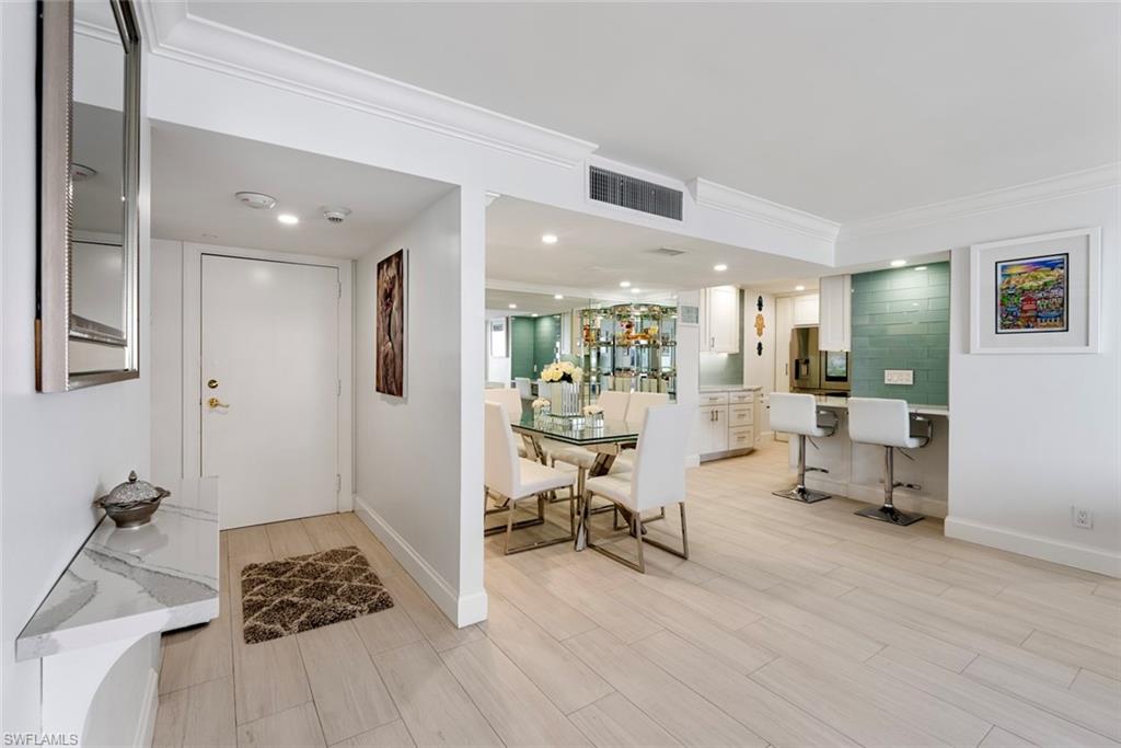 Entrance foyer featuring tile walls and ornamental molding