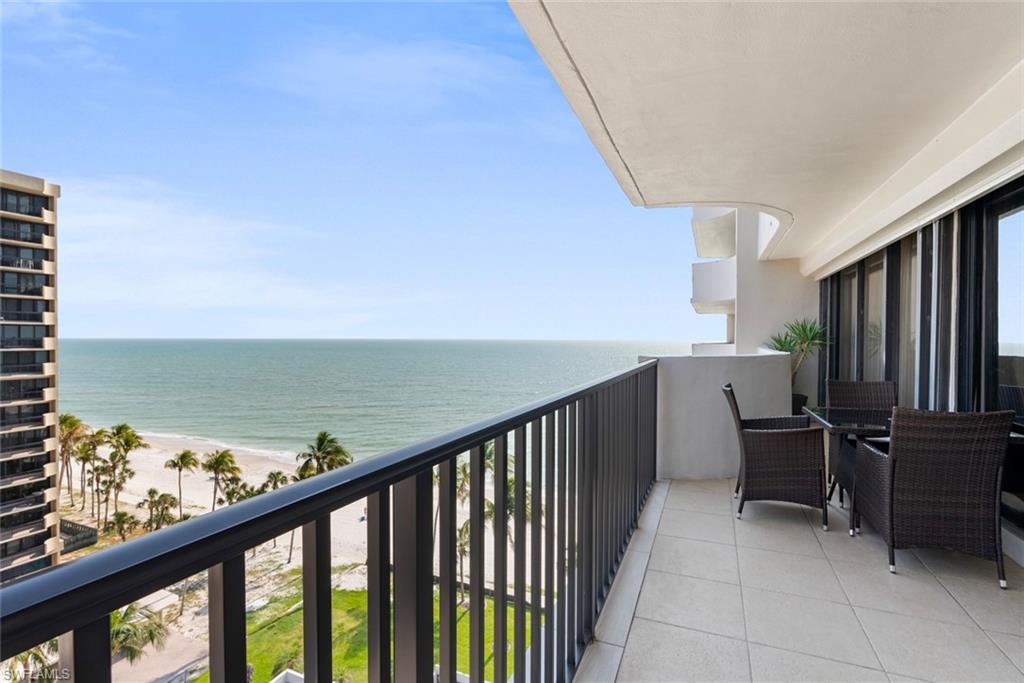 Balcony featuring a beach view and a water view