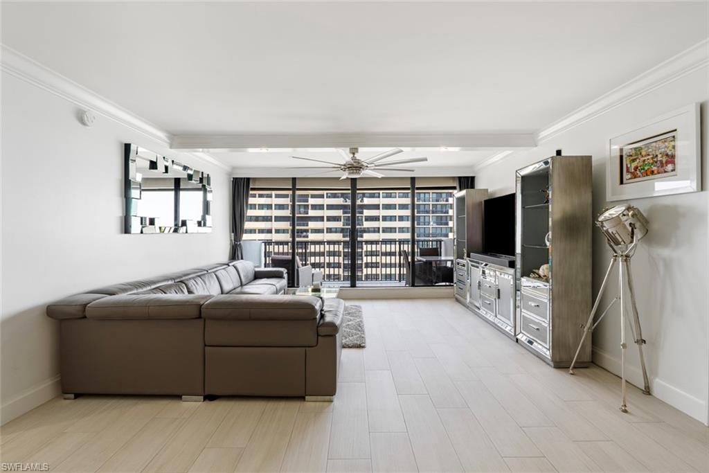 Living room featuring crown molding, light hardwood / wood-style flooring, ceiling fan, and expansive windows