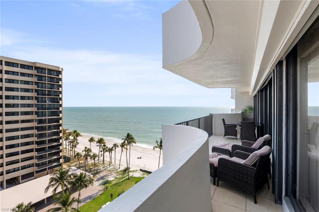 Balcony featuring a beach view and a water view