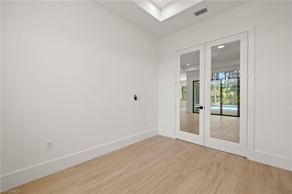 Unfurnished room with light wood-style floors, baseboards, and visible vents