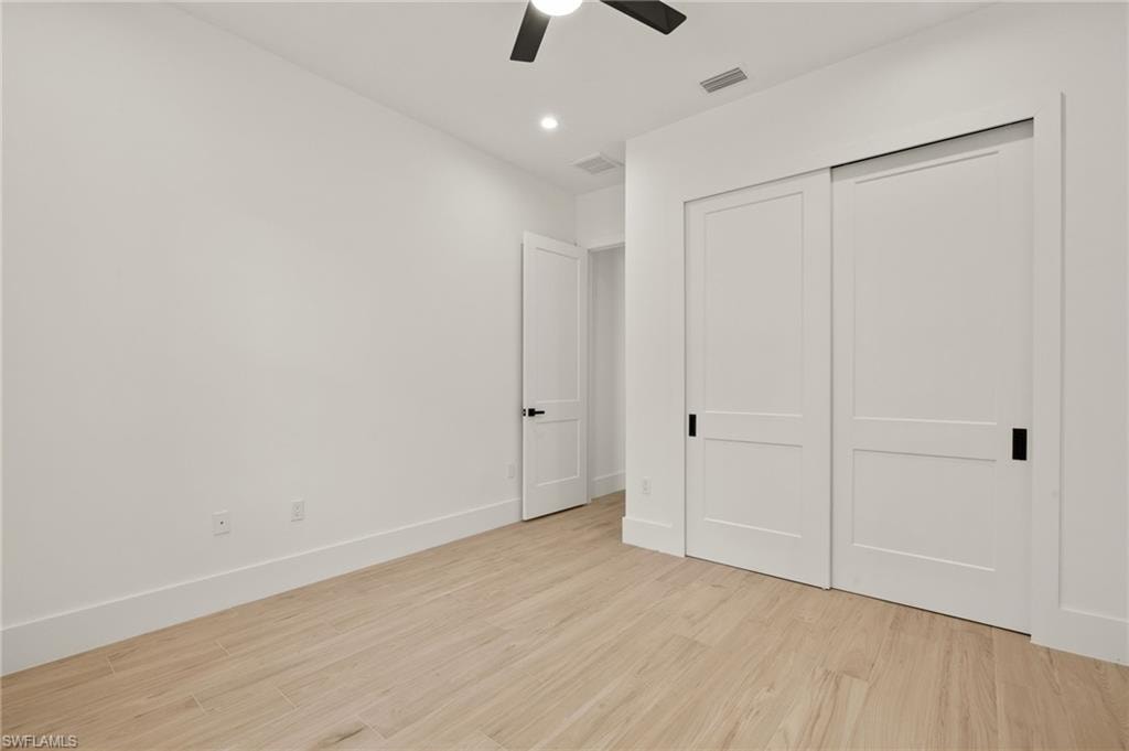 Unfurnished bedroom with visible vents, baseboards, a closet, ceiling fan, and light wood finished floors