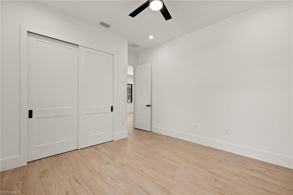 Unfurnished bedroom featuring a closet, visible vents, light wood-type flooring, and baseboards