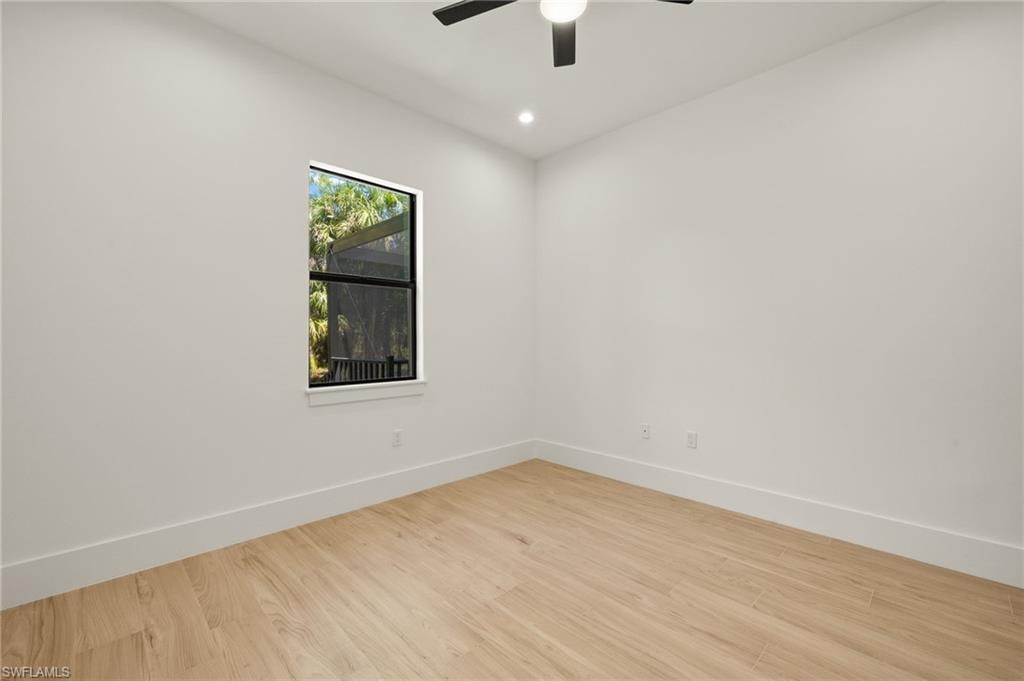 Empty room with wood finished floors, ceiling fan, baseboards, and recessed lighting