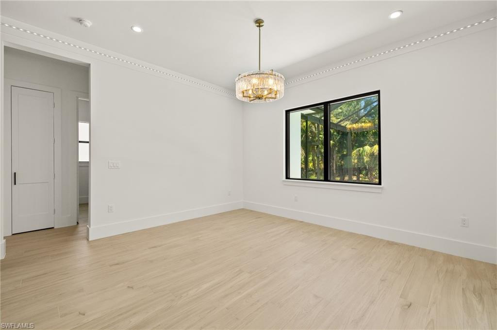 Unfurnished room featuring baseboards, light wood finished floors, an inviting chandelier, and recessed lighting