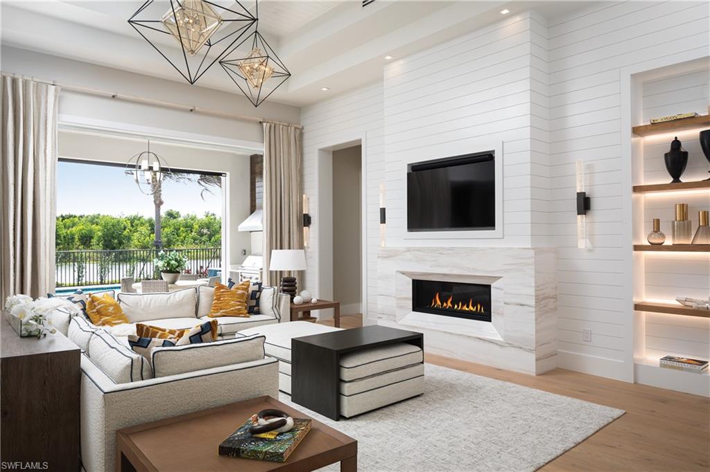 Living room featuring a notable chandelier, light hardwood / wood-style floors, and a fireplace